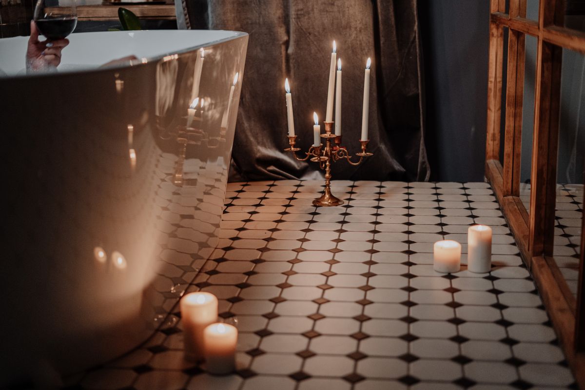 A serene candlelit bath — a warm, restorative self-care ritual