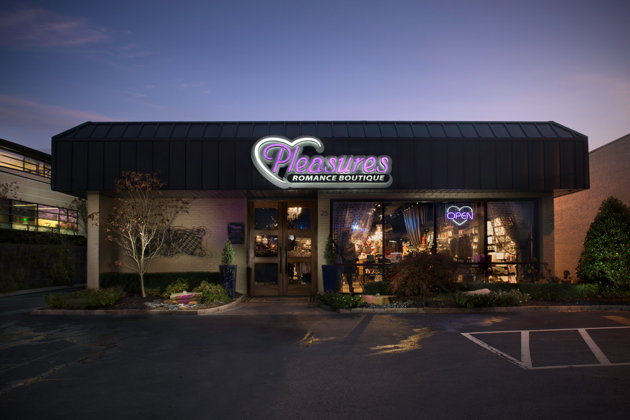 Pleasures Romance Boutique storefront at dusk